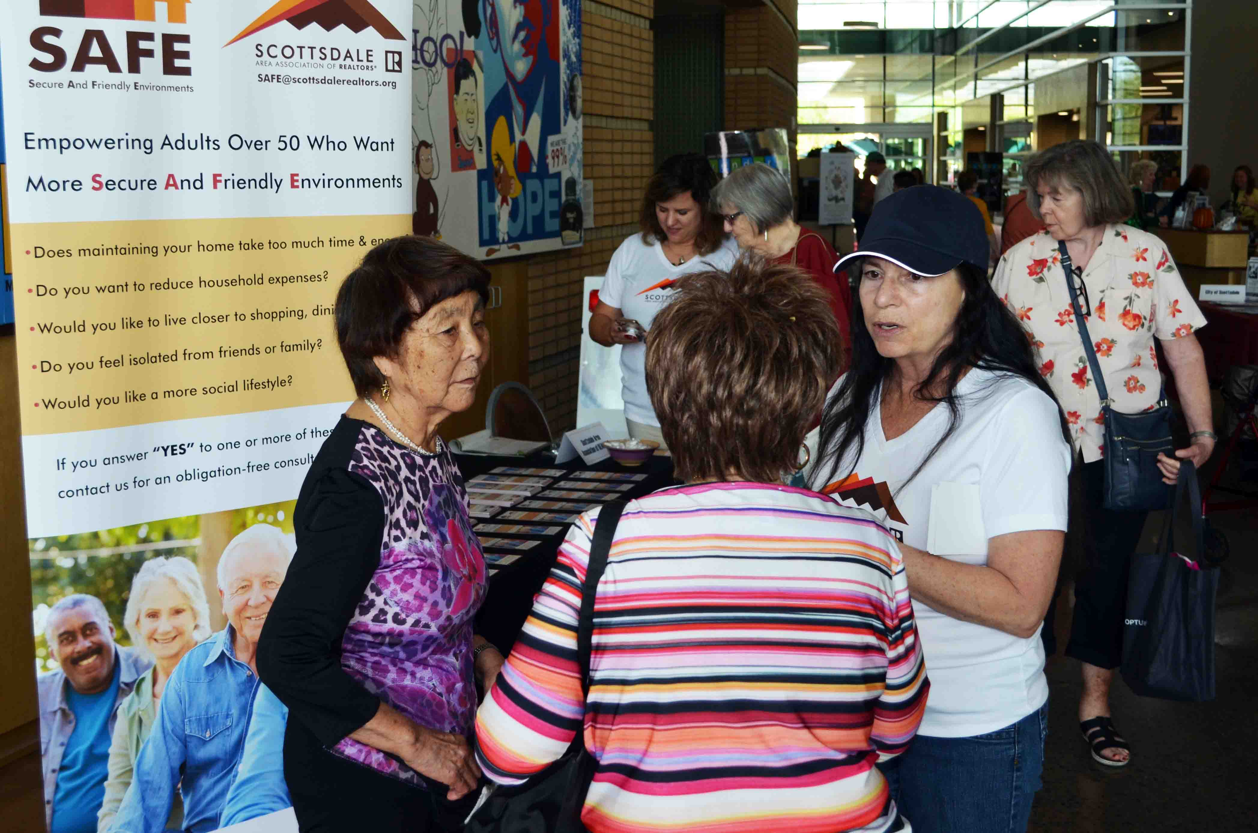 SAFE Ambassadors Jennifer Bingham (in cap) and Kathy Rios explain a new program for seniors offered by the Scottsdale Area Association of REALTORS.