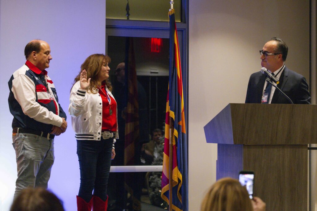 Caption: Polly Blackwell is flanked by her husband Tom while being sworn in as the Scottsdale REALTORS® 2026 President by Ali Ozer at Venue8600. (John Duffy | Bear Lens Photography)